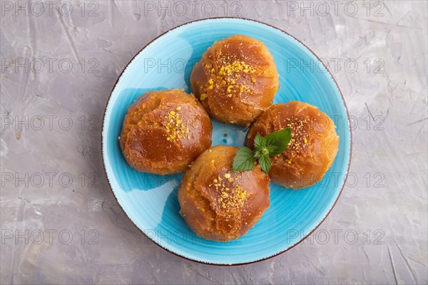 Homemade traditional turkish dessert sekerpare with almonds and honey on gray concrete background.