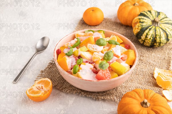 Vegetarian fruit salad of yogurt pumpkin, tangerine, pomegranate, grapefruit, basil microgreen