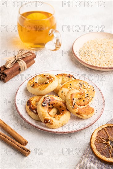 Homemade asian salted cookies, cup of green tea on gray concrete background and linen textile. side