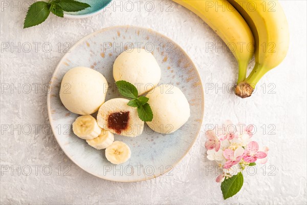 Japanese rice sweet buns mochi filled with jam and cup of coffee on a gray concrete background. top