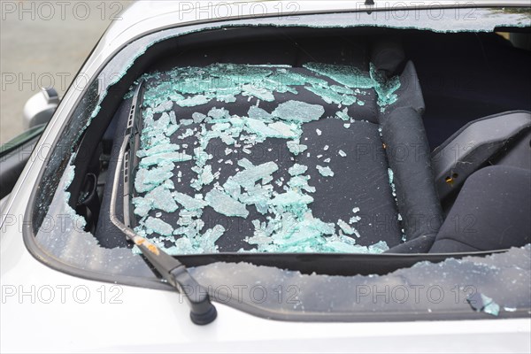 Accident car, sporty car with accident damage standing on a road, broken rear view window of a car