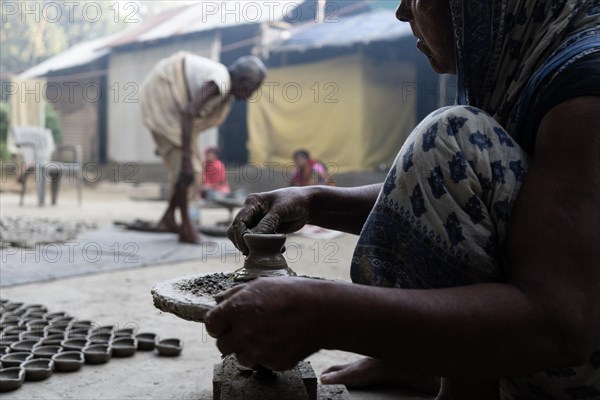 BARPETA, INDIA, NOVEMBER 7: A woman makes earthen lamps or Diyas at her residence ahead of the