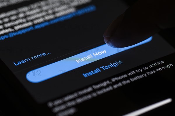 In this photo illustration a person installs updates of iOS 17.3 on an iPhone device on January 26,