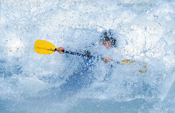 A kayaker almost goes under in a wave in the Isar at the Wittelsbacherbrücke, Munich, Bavaria,