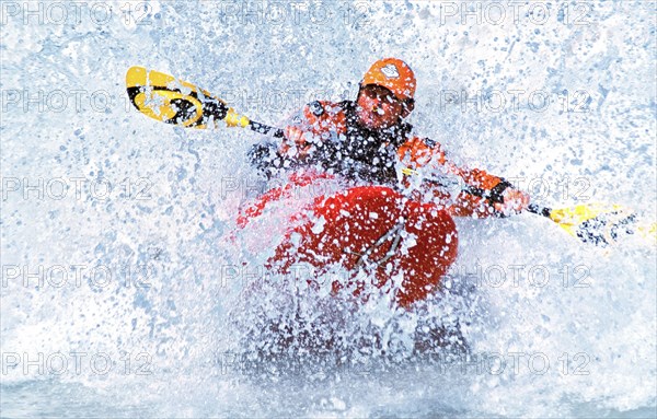 A kayaker rides in the spray in a wave in the Isar at the Wittelsbacherbrücke, Munich, Bavaria,
