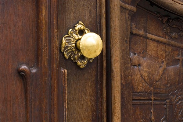 Worn brass doorknob on a dark wooden door of the Asamkirche, Sendlinger Straße, Munich, Bavaria,