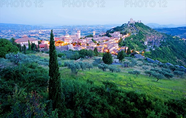 View over Assisi in the early morning, blue hour, with the Rocca Maggiore castle on a hill next to