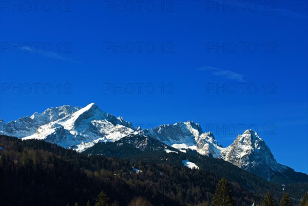 Mountain panorama of the snow-covered Wetterstein mountains in spring, with Alpspitze on the left,
