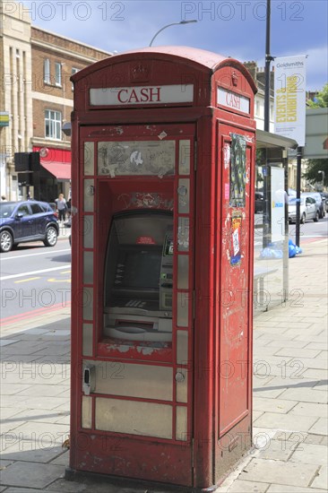 Traditional red telephone kiosk converted to ATM cash machine, New Cross, Deptford, south London,