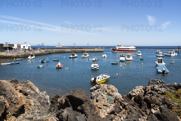 Harbour and ferry boat in the fishing village of Orzola, Lanzarote, Canary Islands, Spain, Europe