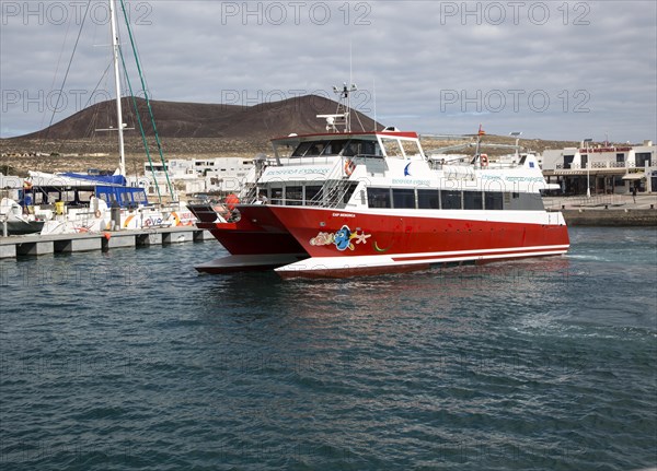 Tourist ferry boat Biosfera Express leaving the harbour Caleta de Sebo, La Isla Graciosa,