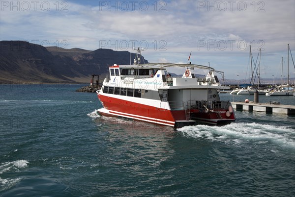 Tourist ferry boat Biosfera Express leaving the harbour Caleta de Sebo, La Isla Graciosa, with