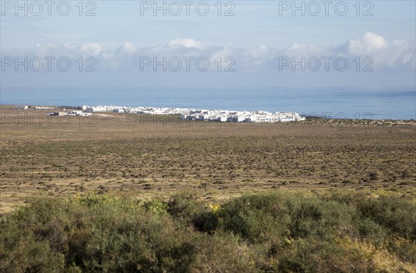 White cuboid buildings of coastal village La Caleta de Famara, Lanzarote, Canary islands, Spain,