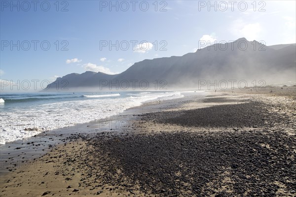 Atlantic Ocean coast beach and waves with morning sea mist, Caleta de Famara, Lanzarote, Canary