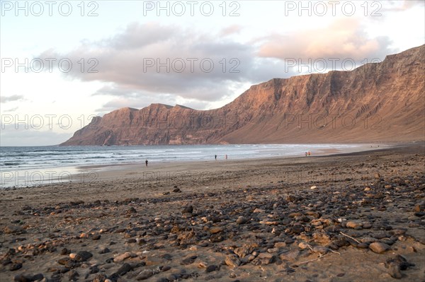 Evening sunset light on beach and cliffs La Caleta de Famara, Lanzarote, Canary islands, Spain,