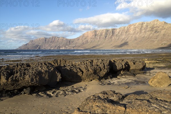 Late afternoon light on beach and cliffs La Caleta de Famara, Lanzarote, Canary islands, Spain,