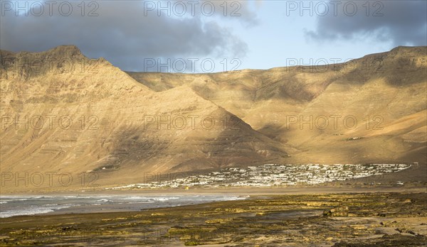 Late afternoon light on beach and cliffs La Caleta de Famara, Lanzarote, Canary islands, Spain,
