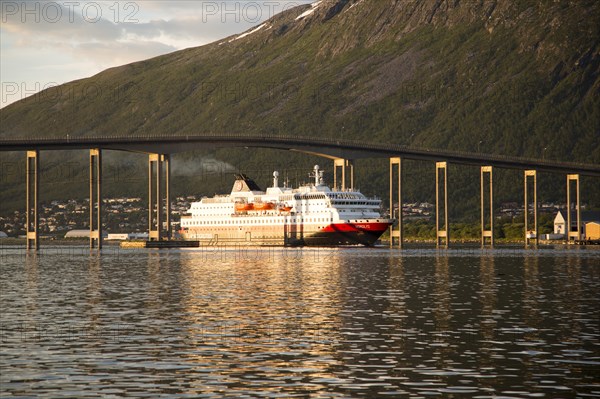 Hurtigruten ferry ship Nordlys approaching Tromso passing under cantilever bridge, Norway, Europe