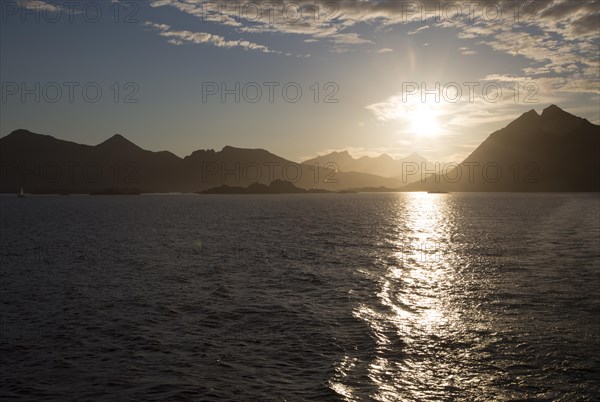 Midnight sun low in sky over mountains near Stamsund, Lofoten Islands, Nordland, Norway, Europe