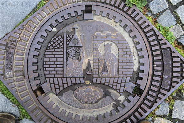 Looking down on old iron manhole cover in city of Trondheim, Norway, Europe