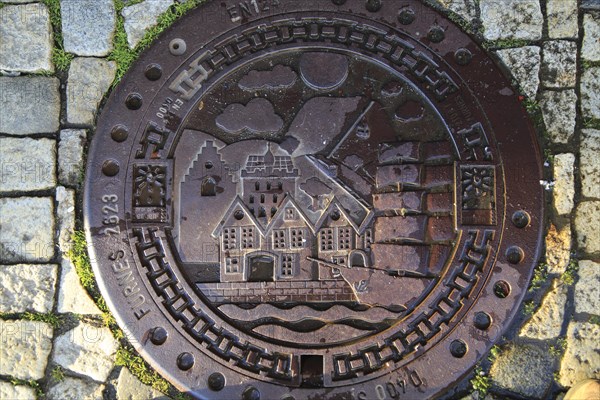 Looking down on old metal manhole cover city of Bergen, Norway, Europe