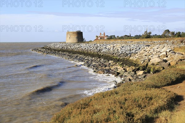 Martello tower W defended by rock armour from coastal erosion, East Lane, Bawdsey, Suffolk,