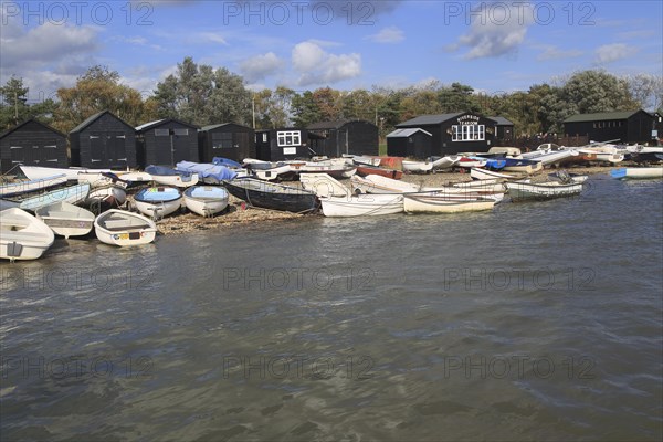 Dinghy boats and black wooden fishing sheds, River Ore, Orford, Suffolk, England, UK