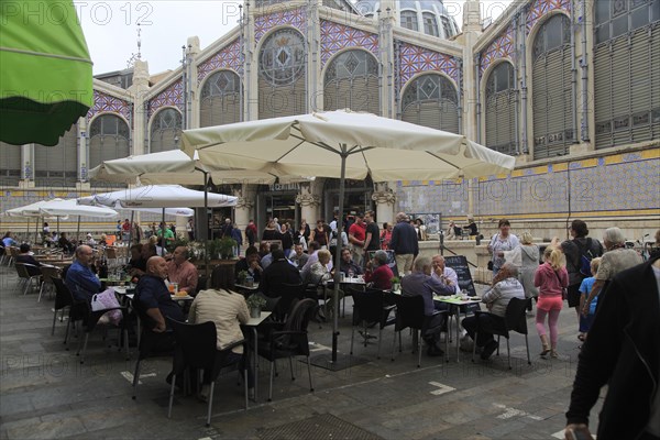 Street cafe tables outside central market building, city of Valencia, Spain, Europe