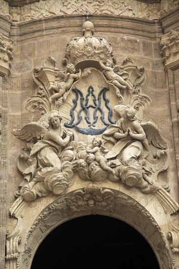 Ornately carved decorated stonework above the entrance to the cathedral church in city of Valencia,