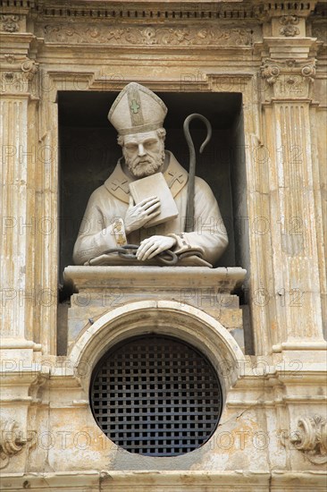 Statue of Christian bishop carved stonework of the cathedral church building in city of Valencia,