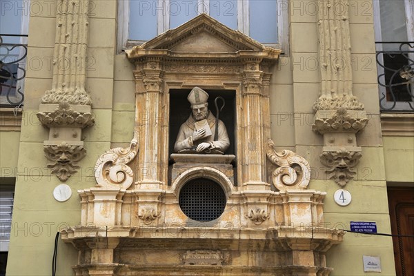 Statue of Christian bishop carved stonework of the cathedral church building in city of Valencia,
