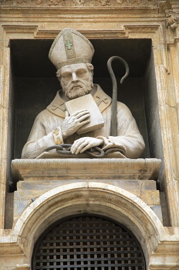 Statue of Christian bishop carved stonework of the cathedral church building in city of Valencia,