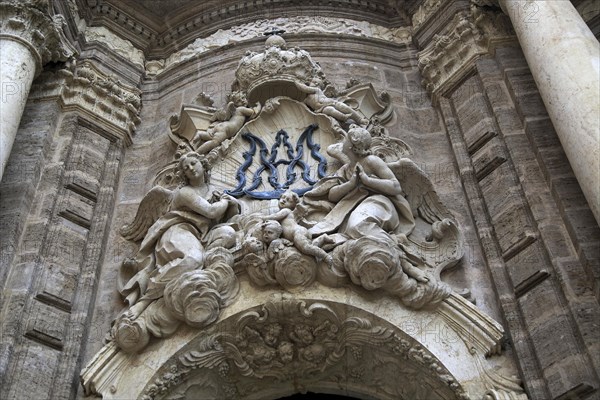 Ornately carved decorated stonework above the entrance to the cathedral church in city of Valencia,