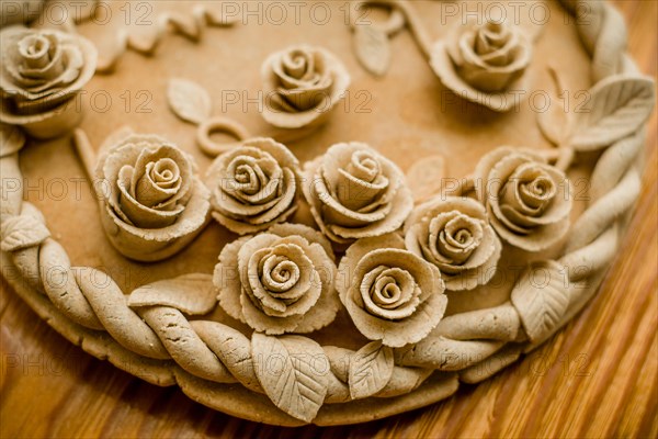 Image of a pastel beige dough sculpture with rose patterns, Teig, gebacken
