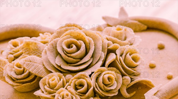 Closeup of rose patterns beige dough sculpture, Teig, gebacken