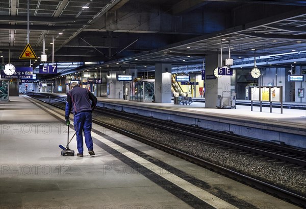 A Deutsche Bahn service employee cleans the platform at Südkreuz station. The fourth train drivers'