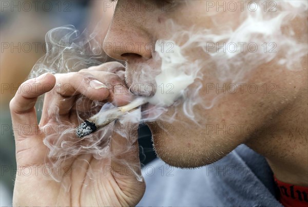 A man smokes a joint during a demonstration in favour of legal marijuana use. The demonstrators