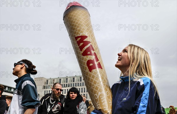 A woman holds a model of a giant joint during a demonstration in favour of legal marijuana use. The