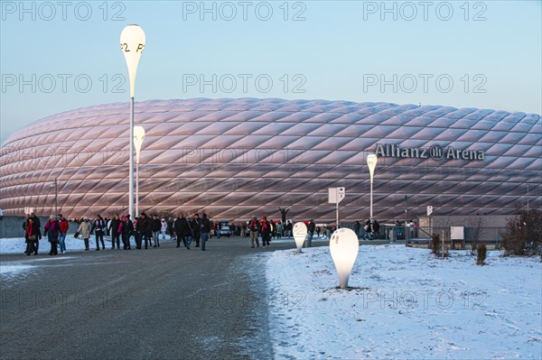 Mourners on their way home, behind them the Allianz Arena in the evening light, FC Bayern Munich
