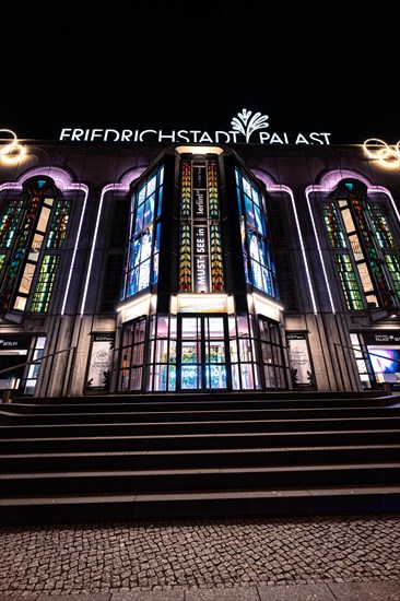 Night view of the illuminated Friedrichstadt-Palast with its characteristic façade and windows,