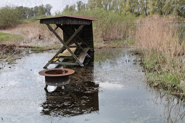Tourist infrastructure, flooded rest area with fire bowl on the banks of the River Peene, Peene