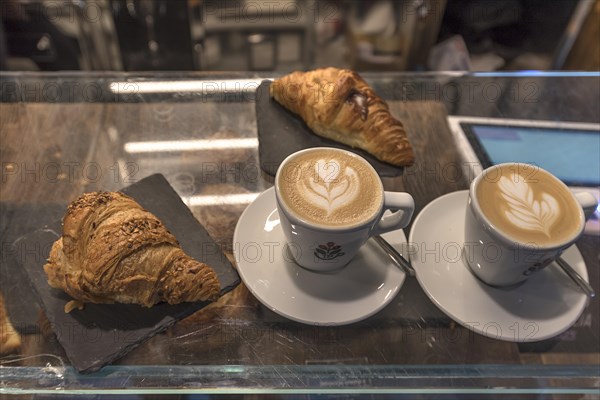 Two cappuccinos and two croissants in a café, Genoa, Italy, Europe