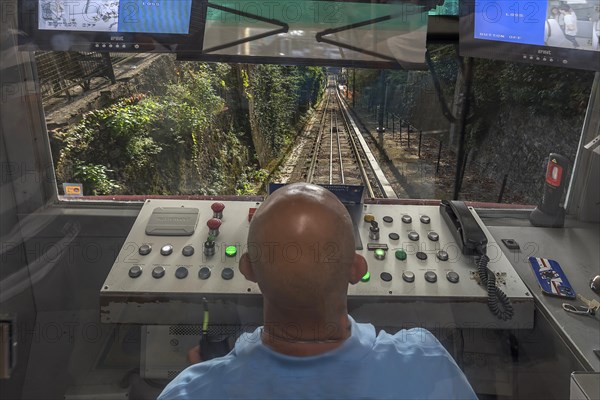 Driver at the driver's desk during the descent of the funicular funicolare Zecca Righi to the city