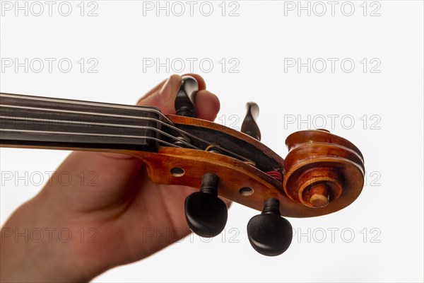 Child's hand tuning viola, studio shot, white background, Germany, Europe