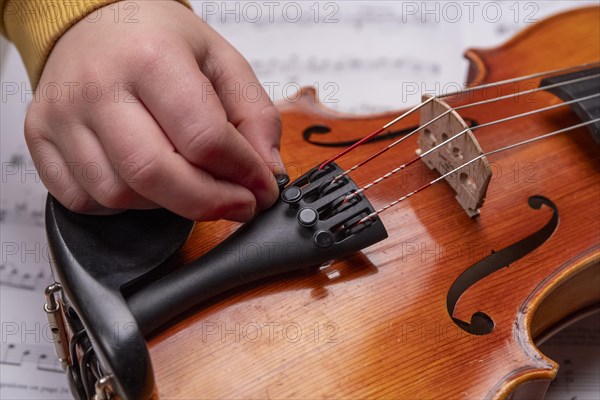 Children's hand tuning viola on the fine tuners, studio recording, Germany, Europe