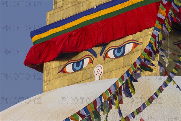 Buddhist prayer flags and eyes of Buddha, the Wisdom Eyes, painted on the golden spire of