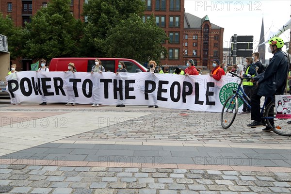 Demonstrators hold a banner with the inscription Power to the people at the alliance demo on