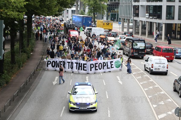 Police car and demonstrators behind banner with the inscription Power to the people at the alliance