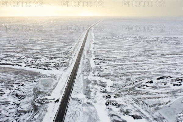 Aerial view over Route 1, Ring Road, two-lane national road in desolate snow covered winter