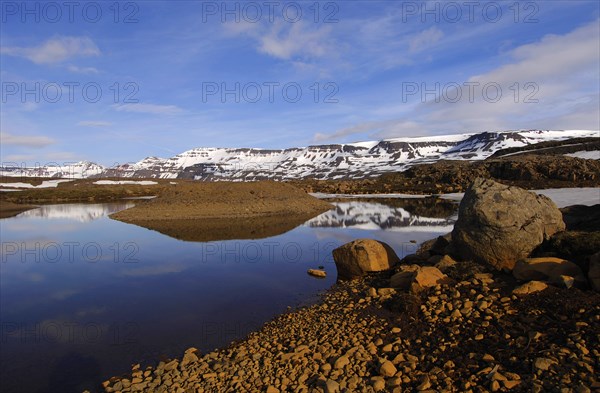 Rock-rimmed meltwater pool in the Fjardarheidi range near Seydisfjordur, east Iceland